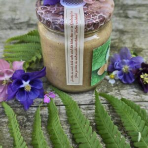 Glas Haselnuss im Honig von Bienen Trax im Freien mit Blüten und Zitat-Banderole